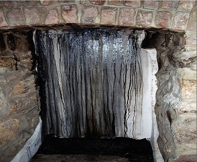 A very dirt fireplace due to use of freshly cut timber.
